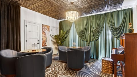 Stylish lounge with custom bar, plush seating, and statement chandelier.