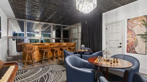 Stylish lounge with custom bar, plush seating, and statement chandelier.