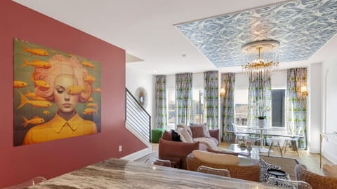 Stylish living room with statement ceiling, chandelier, and lounge seating.