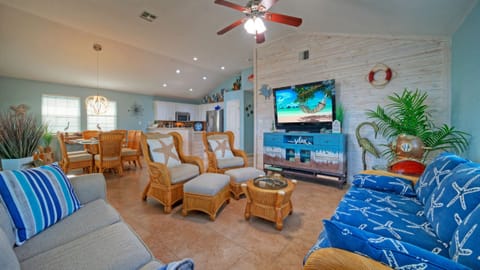 Main living area featuring nautical decor, wicker furniture, and a wall-mounted TV.
