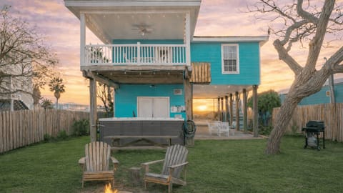 Rear exterior of the house showing the deck, hot tub, and yard.