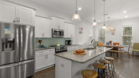 Modern, open-concept kitchen with stainless steel appliances and a spacious island with seating.