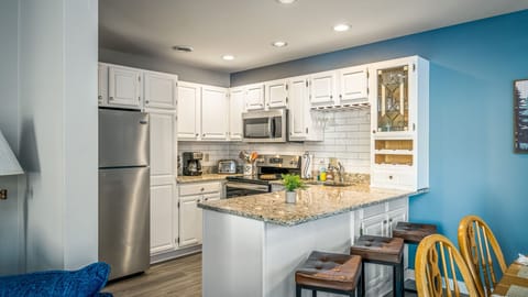 A fully equipped kitchen with granite countertops and bar seating, perfect for easy meals and casual gatherings.