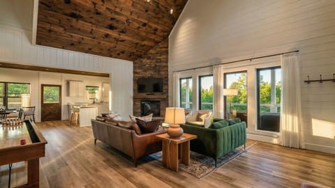 Bright, open living room anchored by a stone fireplace and cozy seating, perfect for relaxing after a day in the mountains.