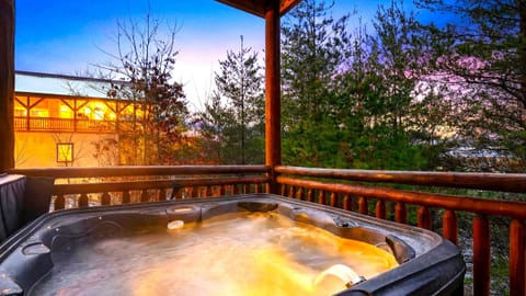 Unwind in the private hot tub as the Smoky Mountains glow at twilight—peaceful forest views, crisp mountain air, and the perfect spot to relax after a day of adventure.