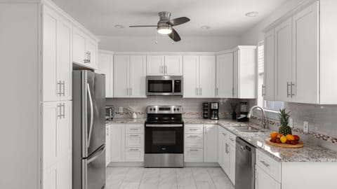 Sleek white cabinetry and a full stainless steel appliance suite.
