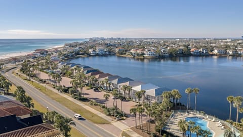 Aerial views showcasing the coastal setting—overlooking the lake, nearby homes, and the beach just moments away, with the community pool nestled along the waterfront.