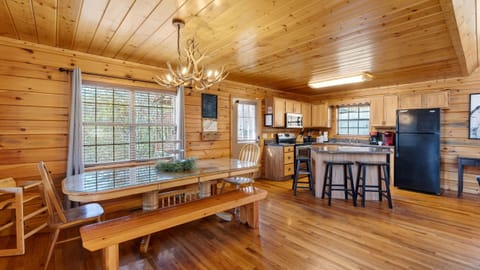 Dining area with a view of the kitchen, featuring an antler-style chandelier.