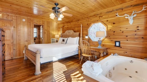 Primary suite featuring a king-sized bed and an in-room jetted soaking tub.