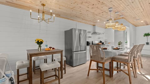 Dining area, a secondary view of the high-top table and the kitchen island beyond.