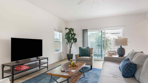 Welcome to your spacious, sun-filled living room featuring sleek wood-style flooring.
