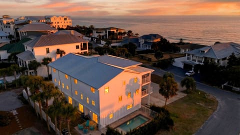 Aerial sunset over the beachside neighborhood—Gulf views, palm-lined streets, and that golden-hour glow.