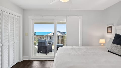 Second-floor primary suite featuring a king bed, TV, private balcony terrace, and a spacious ensuite bathroom.