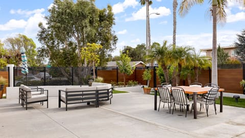 Patio lounge with outdoor seating area, modern furniture, and a large umbrella.