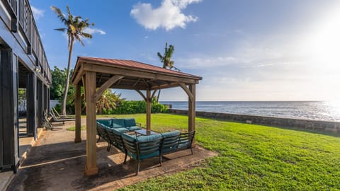 Shaded oceanfront gazebo lounge—kick back on the sectional and unwind to the sound of the waves.