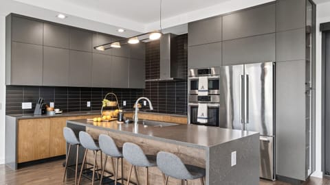 Sleek chef’s kitchen with a spacious island, bar seating, and premium stainless steel appliances.