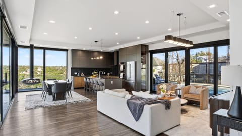 Open-concept living meets designer kitchen—steps from the pool through wall-to-wall glass.