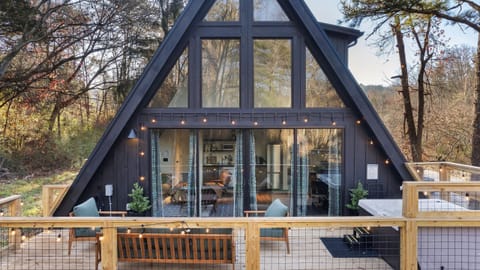 Striking A-frame in the trees with a spacious deck, string lights, and a private hot tub for post-adventure soaks.
