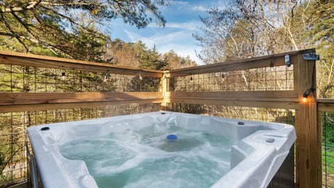 Private hot tub with treetop views—unwind under the string lights after a day in the Smokies.