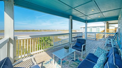 Spacious covered balcony with comfortable seating and sweeping bay views — perfect for morning coffee or sunset cocktails.