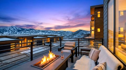 Sip, relax, and take in the sunset—private balcony with a cozy fire table and sweeping mountain views.