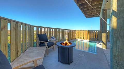 Private patio with pool and firepit—unwind with pond views and coastal breezes from your own outdoor retreat.