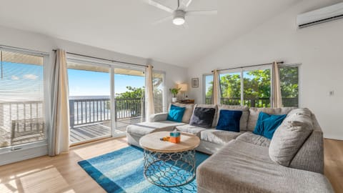 Sunlit upper-level living room with ocean-view lanai—open the sliders and let the island breeze in.