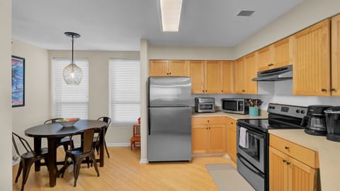 View of the stainless steel refrigerator and the transition to the dining area.