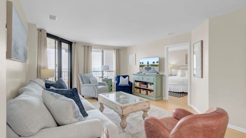 Main living area featuring a blue sofa and balcony access.
