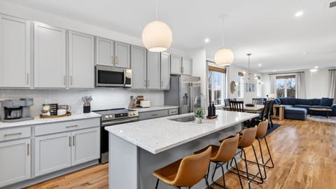 The bright open-concept kitchen features a large island with seating and flows seamlessly into the dining and living areas.