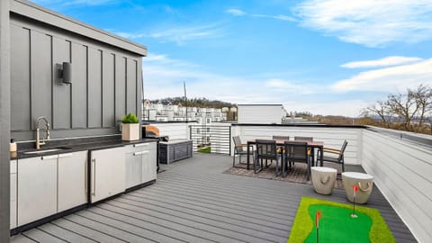 The expansive rooftop features an outdoor kitchen, dining area, and putting green for elevated group hangouts with a view.