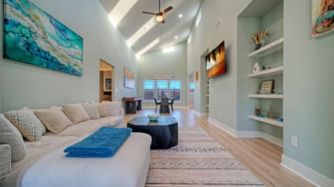 The airy living room features soaring ceilings, plenty of seating, and space for everyone to spread out.