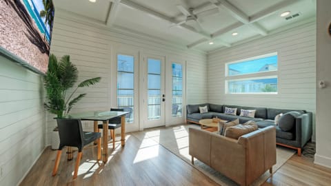 Sunlit living and dining space with balcony access, plush seating, and an open, coastal feel. (Dune & Done)