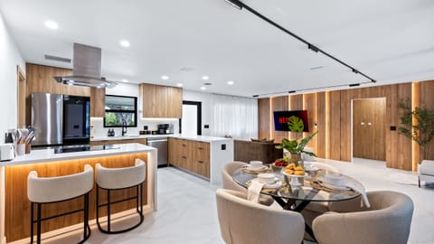 Open-concept kitchen, dining, and living area with a clean modern design.