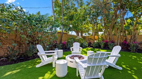 Private fire pit lounge surrounded by lush tropical landscaping.