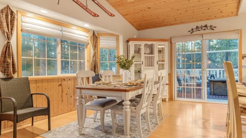 Bright dining area with seating for six and sliding doors leading to the outdoor deck.
