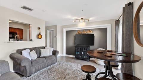 Spacious, modern living room with "Nashville" wall art and comfortable seating.