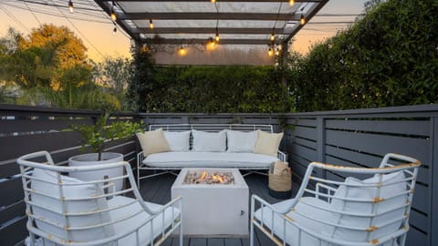 Private patio with lounge seating, string lights, and a firepit for relaxed evenings outdoors.
