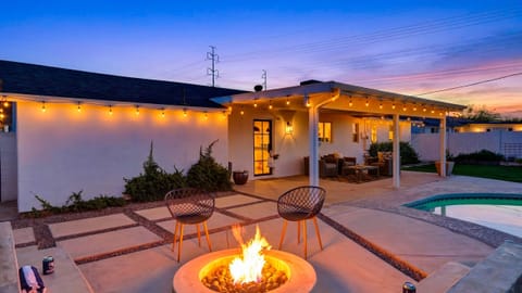 Full view of the backyard patio and firepit under the twilight sky.