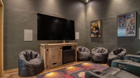 The theater room features a large flat-screen TV and movie theater seats for the ultimate cinematic experience. (Birch Lodge)