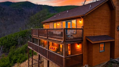 Elevated exterior view of the multi-level log cabin at dusk.