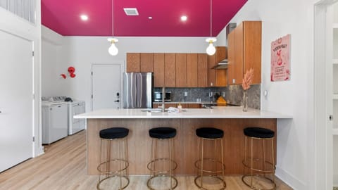 A stylish kitchen with bar seating, stainless steel appliances, and playful design touches.