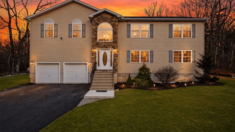 Warm sunset welcome—spacious mountain retreat with inviting curb appeal and room for everyone to gather.