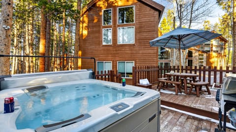 Back deck view featuring a relaxing hot tub and outdoor dining area.