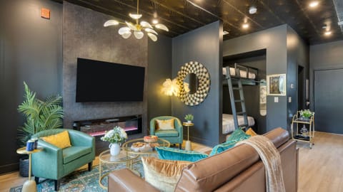 Unit 105: Modern studio with flat-screen TV and electric fireplace.