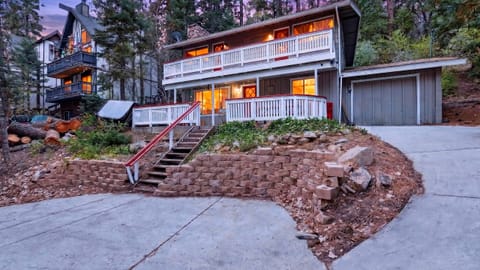 Cozy Big Bear cabin surrounded by pines with warm evening glow.