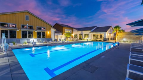 The resort-style communal pool deck is illuminated at night, creating a truly magical atmosphere.