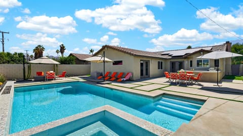 Pristine backyard oasis featuring a sparkling custom pool, expansive concrete paver decking, and premium chaise loungers.