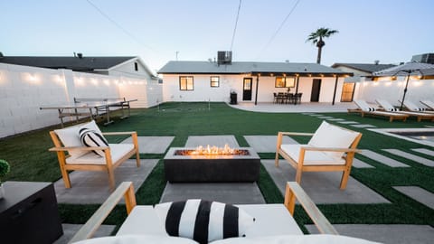 Inviting backyard lounge area centered around a modern rectangular fire pit, ideal for evening entertaining.