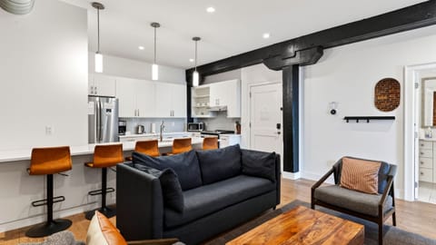 Relax in the modern living area, featuring exposed brick and a sleeper sofa for additional guests.